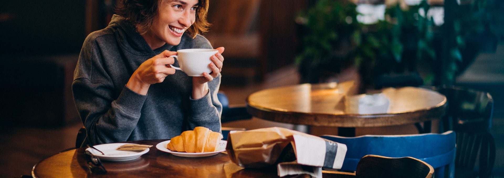 a woman sitting at a table with a cup of coffee at The Tupelo