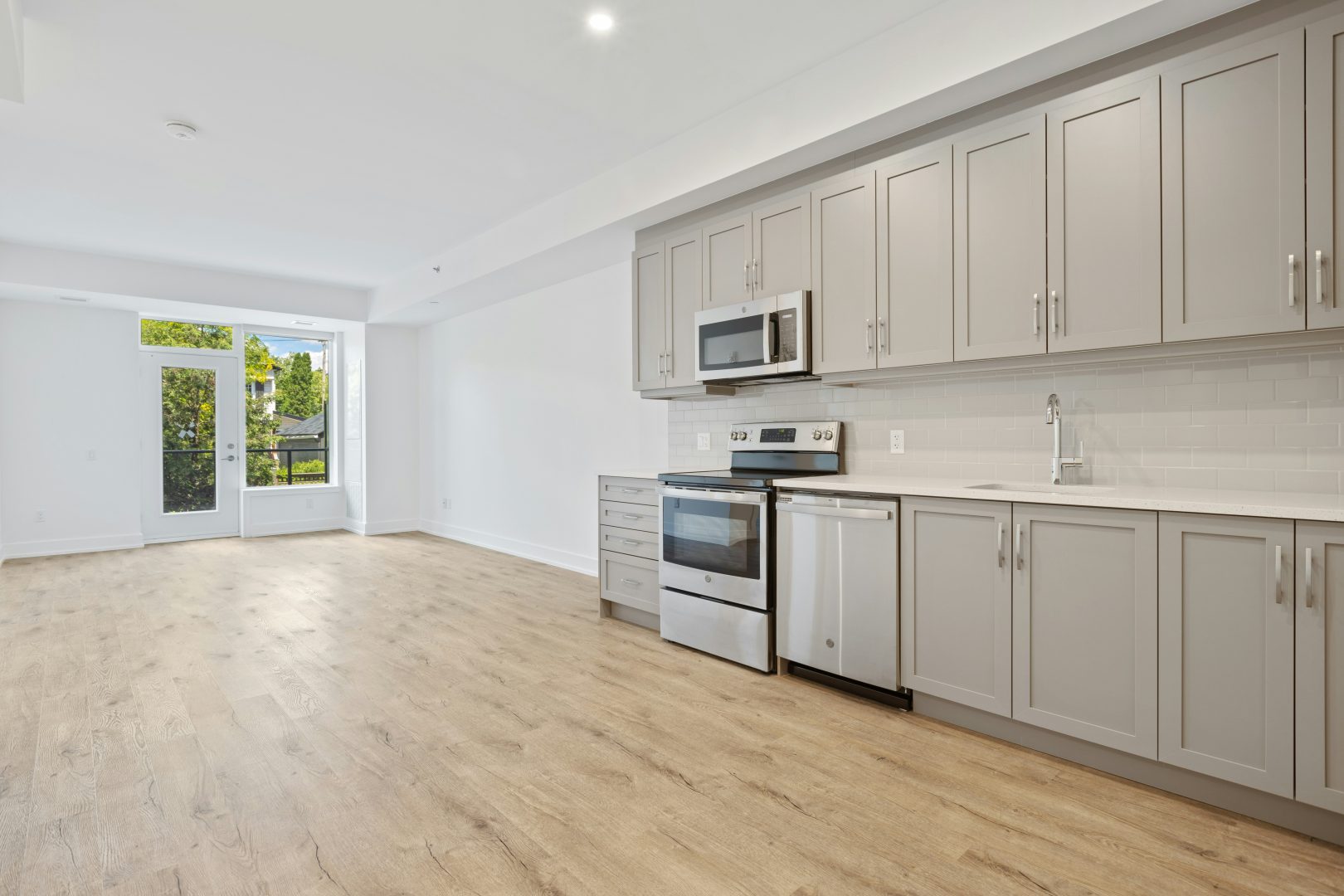 a kitchen with white cabinets and stainless steel appliances at The Tupelo