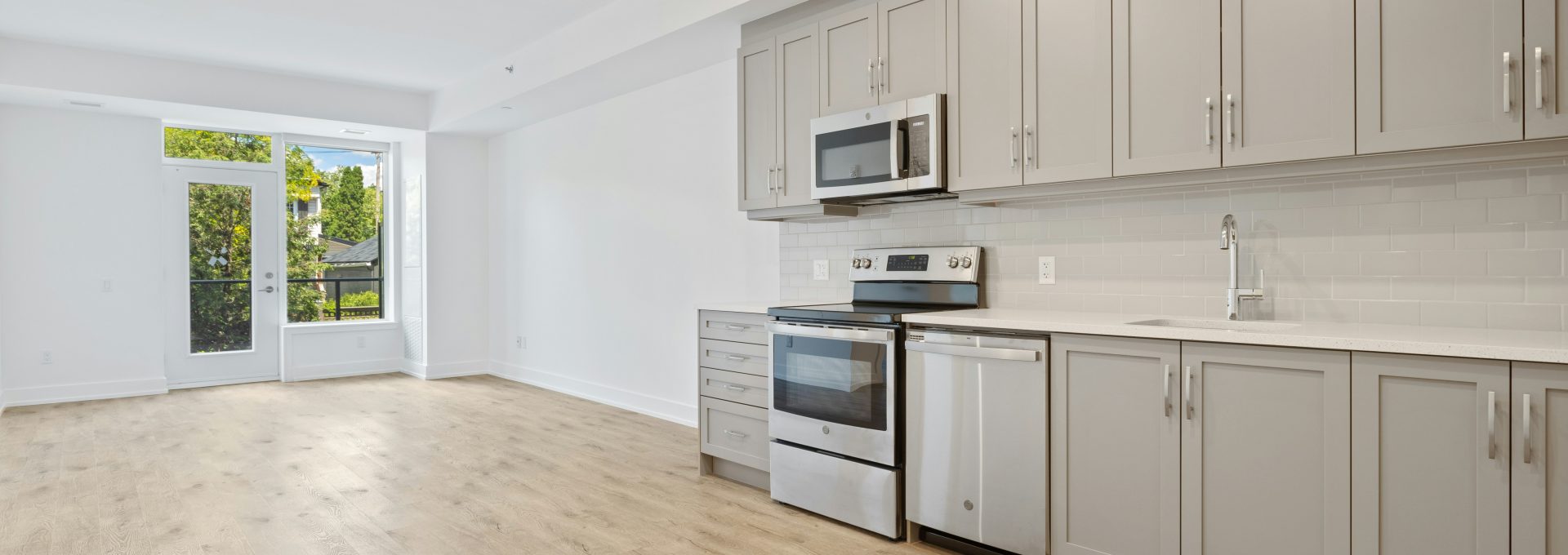 a kitchen with white cabinets and stainless steel appliances at The Tupelo