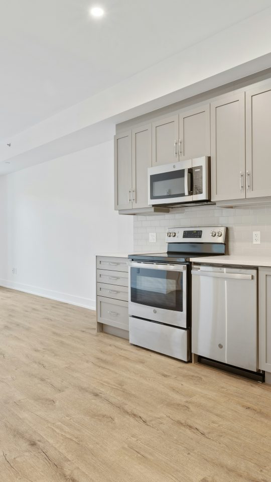 a kitchen with white cabinets and stainless steel appliances at The Tupelo