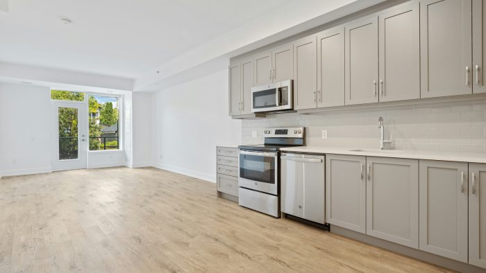 a kitchen with white cabinets and stainless steel appliances at The Tupelo